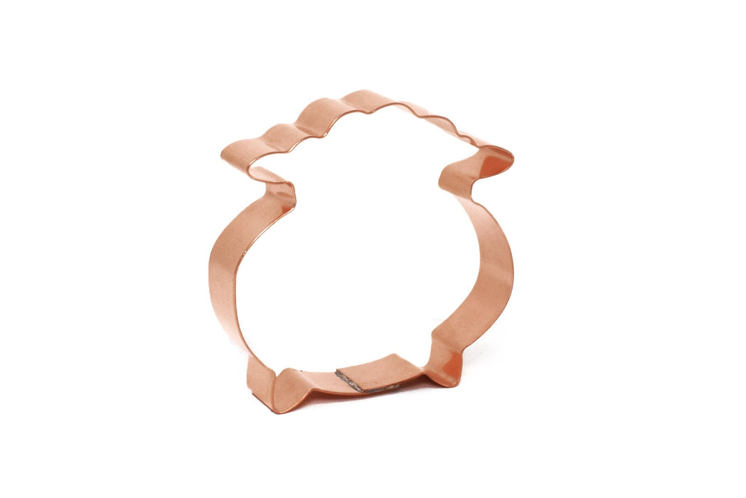 A handmade copper cookie cutter in the shape of a cauldron or pot of gold, on a white background.