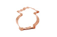 A handmade copper cookie cutter in the shape of a cauldron or pot of gold, on a white background.