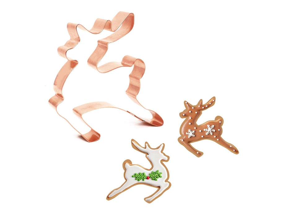 Copper cookie cutters shaped like a cat and reindeer on a white background