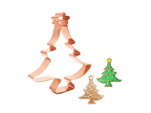 Copper Christmas tree cookie cutter with examples of cookies shaped like a tree on a white background