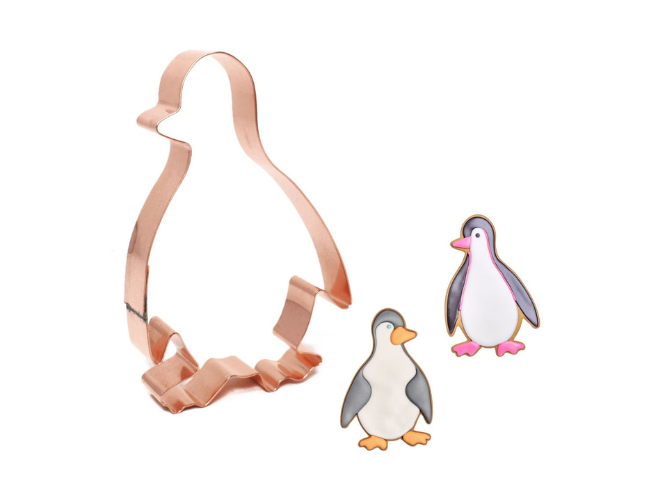 Copper penguin cookie cutter with two penguin illustrations on a white background